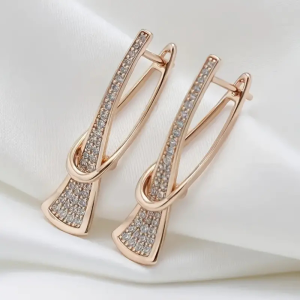 Gold crystal drop earrings with modern sculptural twist design - side angle